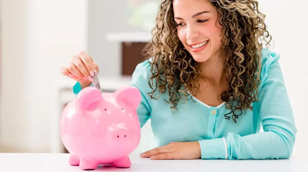 how to save money woman putting money into a piggy bank