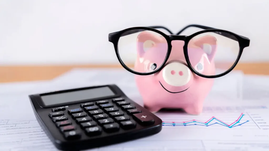 money saving tips, a piggy bank with glasses and a calculator